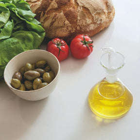 Marquina Oil Cruet in Kitchen with Olives and Vegetables and Artisanal Bread
