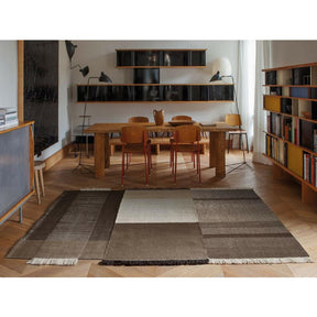Nani Marquina Tres Rug Chocolate in room with Prouve Standard Chairs and Serge Mouille Lamps