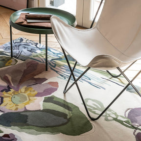 Nanimarquina Flora Backyard Rug by Santi Moix in room with Butterfly Chair