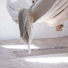Nanimarquina Ilse Crawford Wellbeing Wool Chobi Rug in room with Throw and Hammock