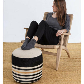 Nanimarquina Kilim Pouf 2 in room with girl in Wegner CH25 Chair