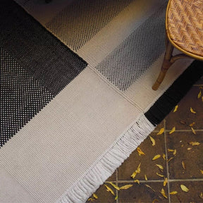 Nanimarquina Tres Outdoor Rug Black with Rattan Cafe Chair