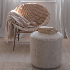 nanimarquina Tres Persian Pouf Vegetal in room with Woven Chair and Books