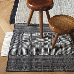 Nanimarquina Tres Rug Black in room with stools