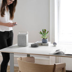 Vifa Oslo Speaker Pebble Grey in home office with woman