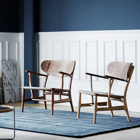 Wegner CH22 Lounge Chairs in Room with Woodlines Rug by Carl Hansen and Son